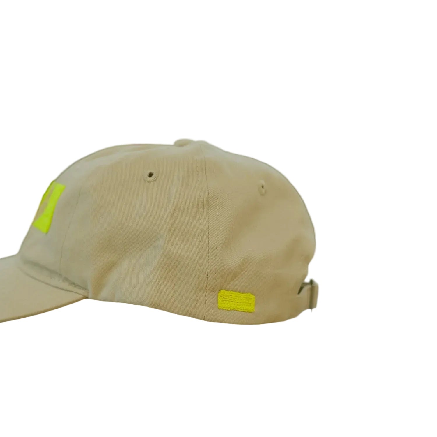 Beige cap with yellow tags on a metallic surface