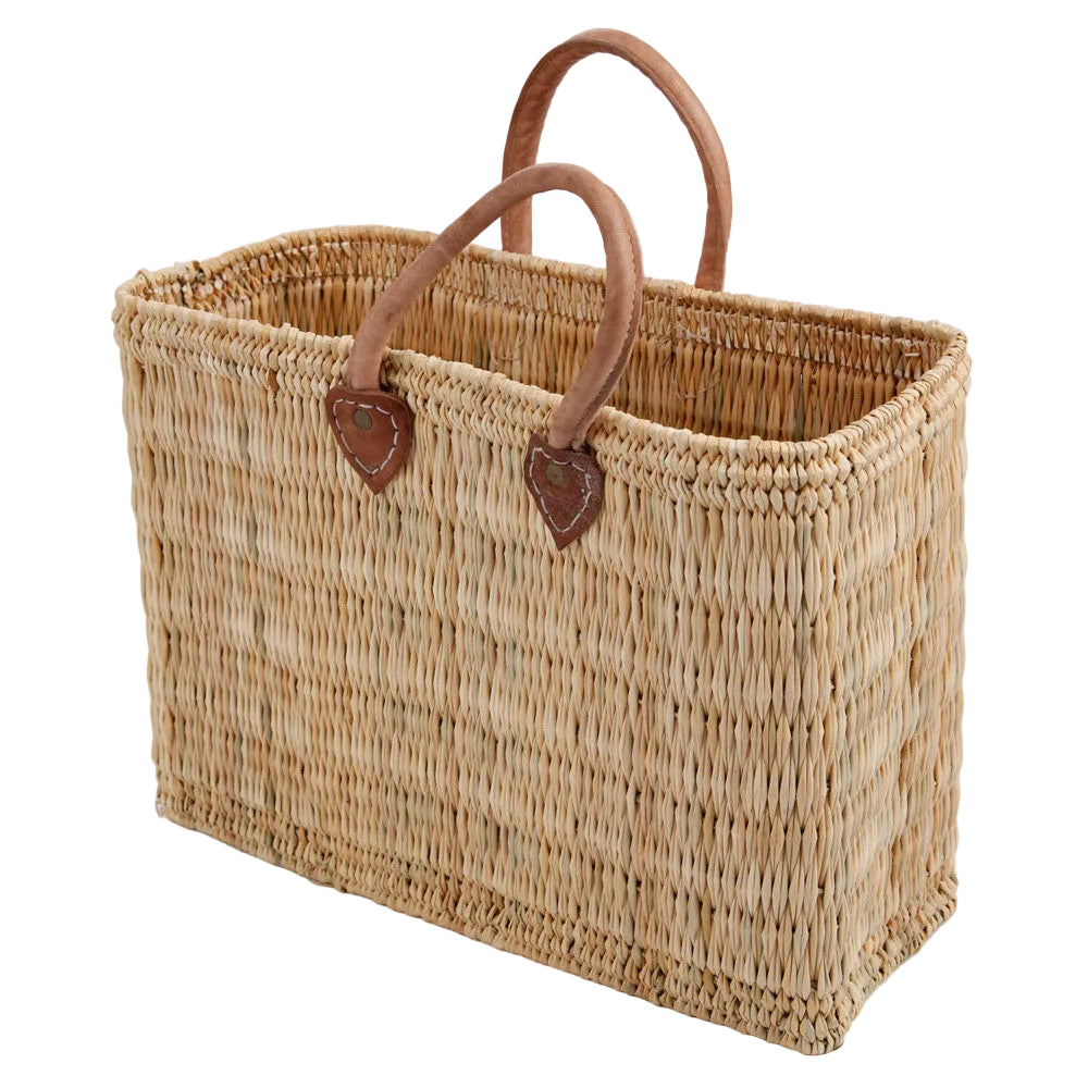Woven basket with leather handles on a light gray background