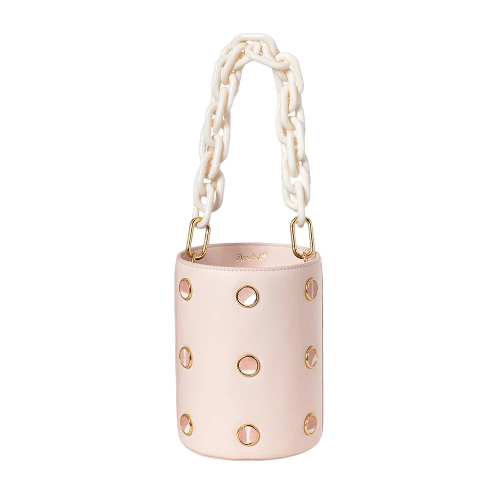 A white bucket bag with green chain strap and gold-tone accents, featuring decorative blue dots.