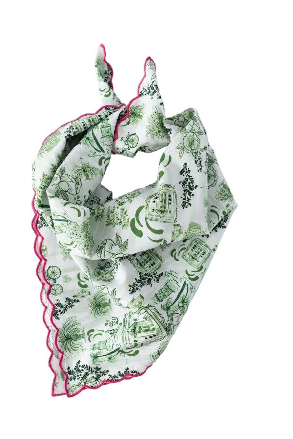 Green patterned baby bib with pink trim on a marble surface