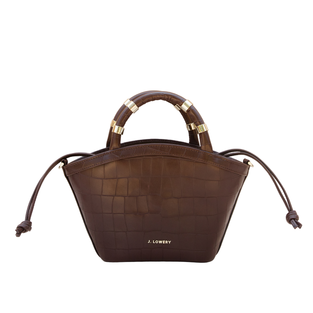 Brown handbag with gold accents on a beige background