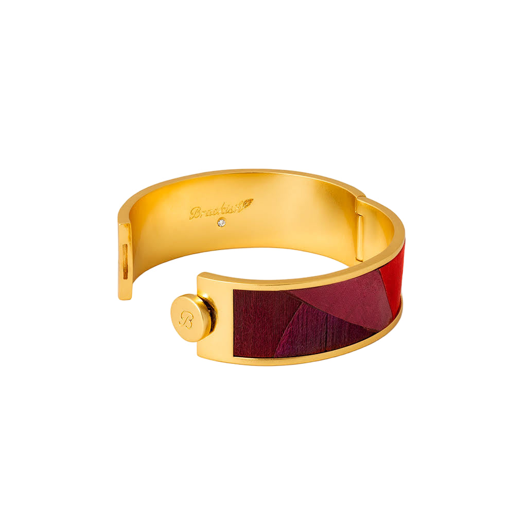 Gold bracelet with a red inlay on a white background