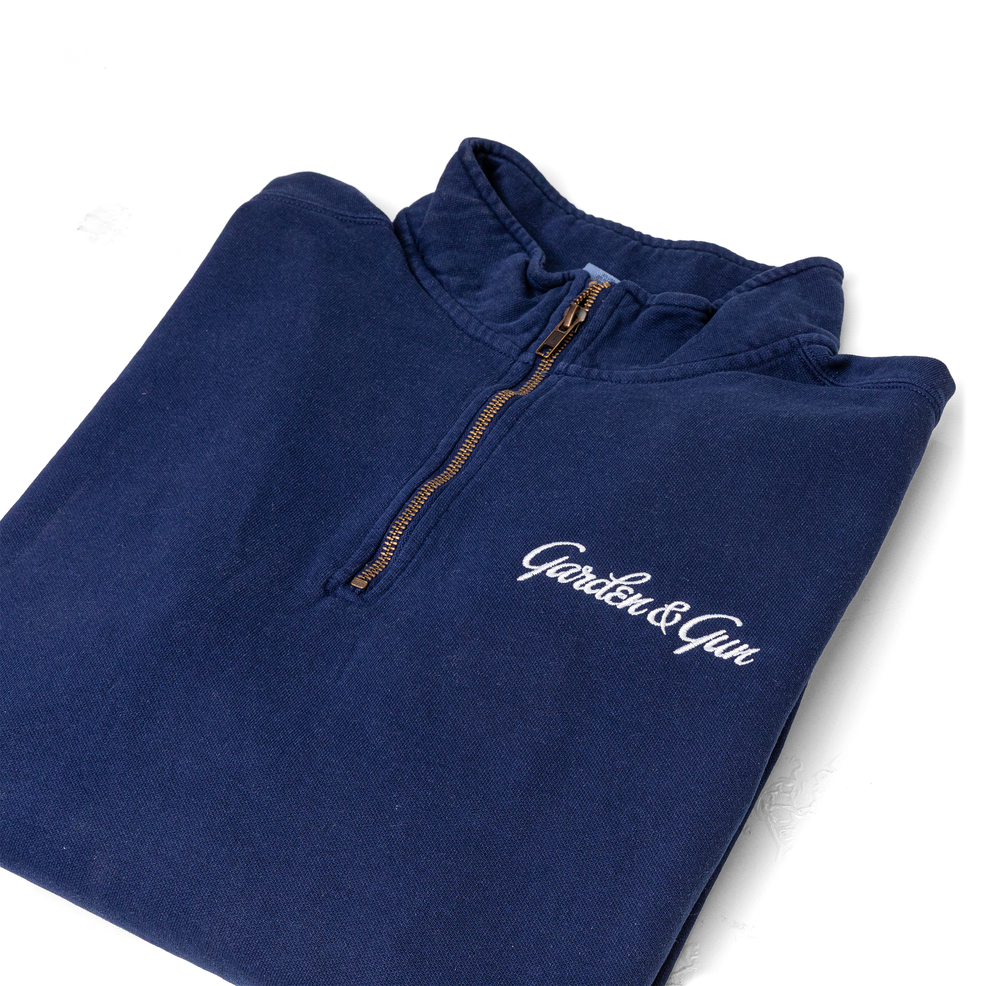 Folded navy blue pullover with 'Garden & Gun' logo on a white background