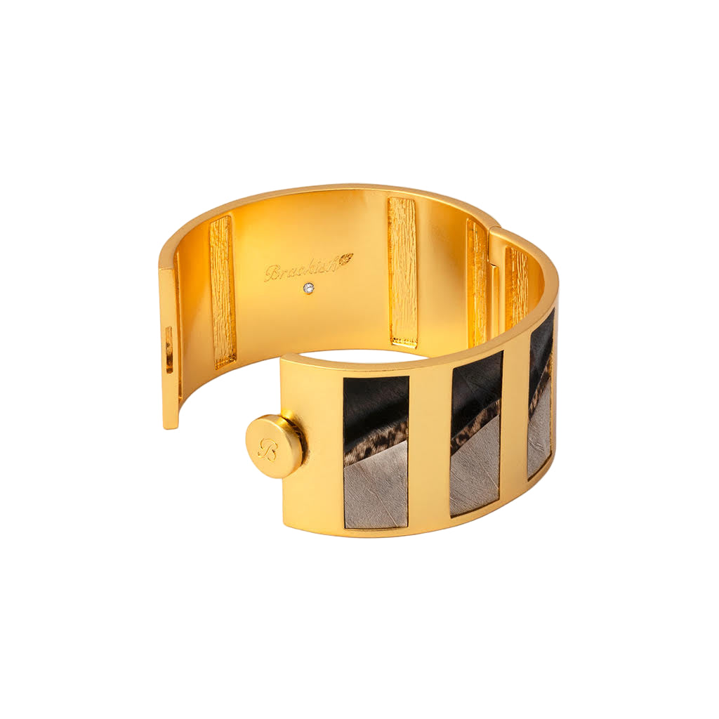 Gold bracelet with a textured design on a white background
