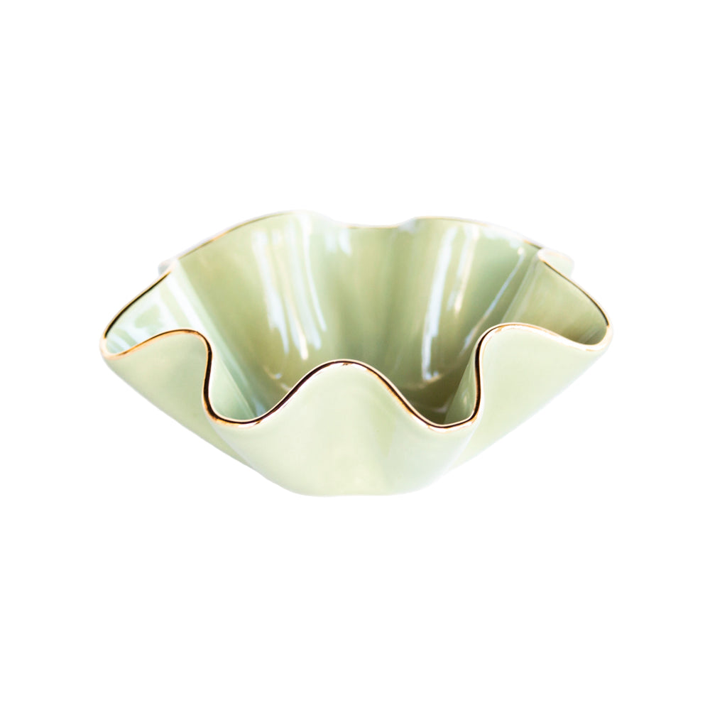 Green ceramic bowl with wavy edge on a white background