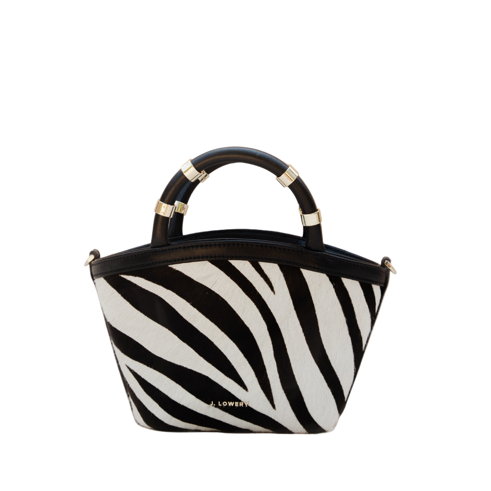 Zebra print handbag with black handle on a beige background