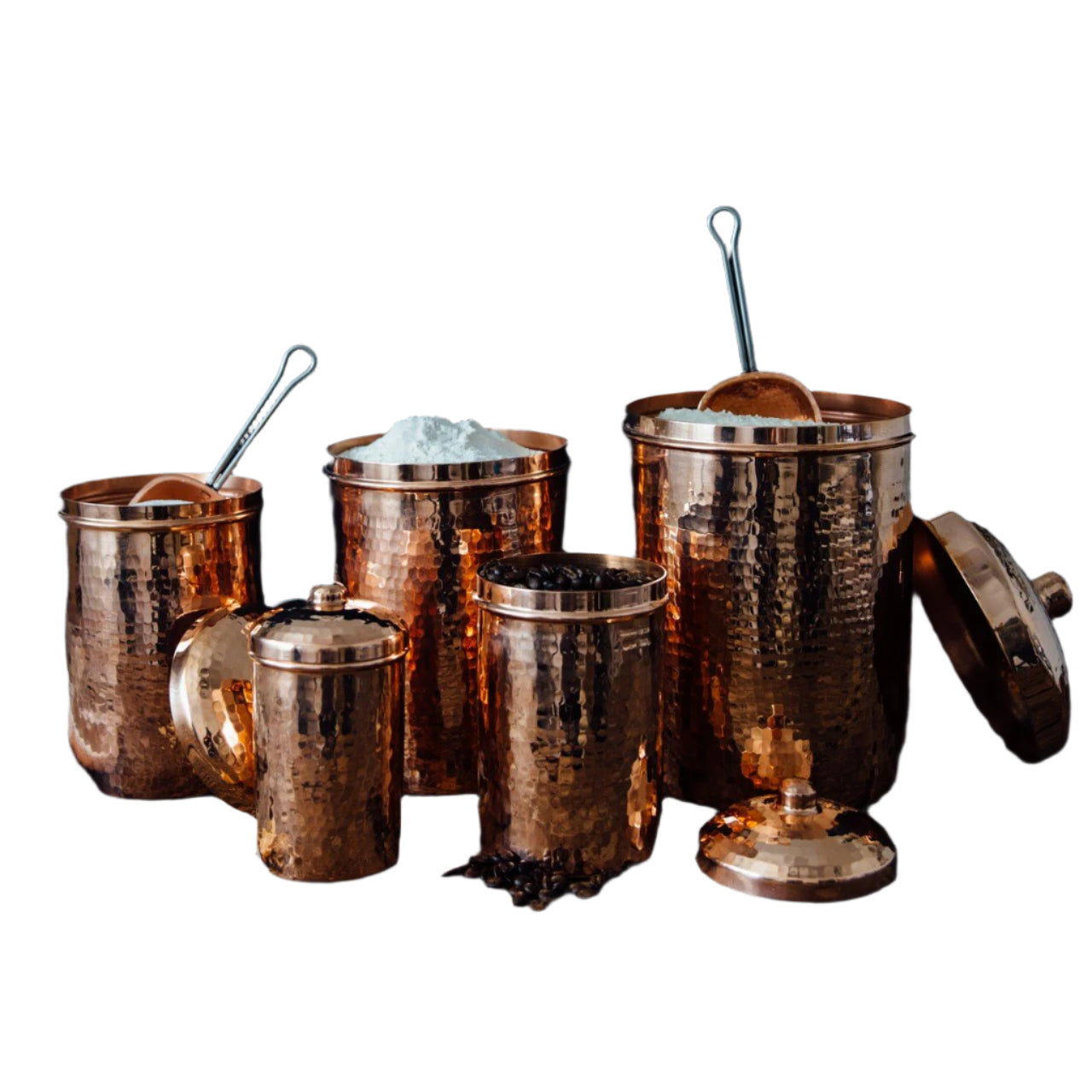 Set of copper canisters with lids on a wooden surface against a dark background