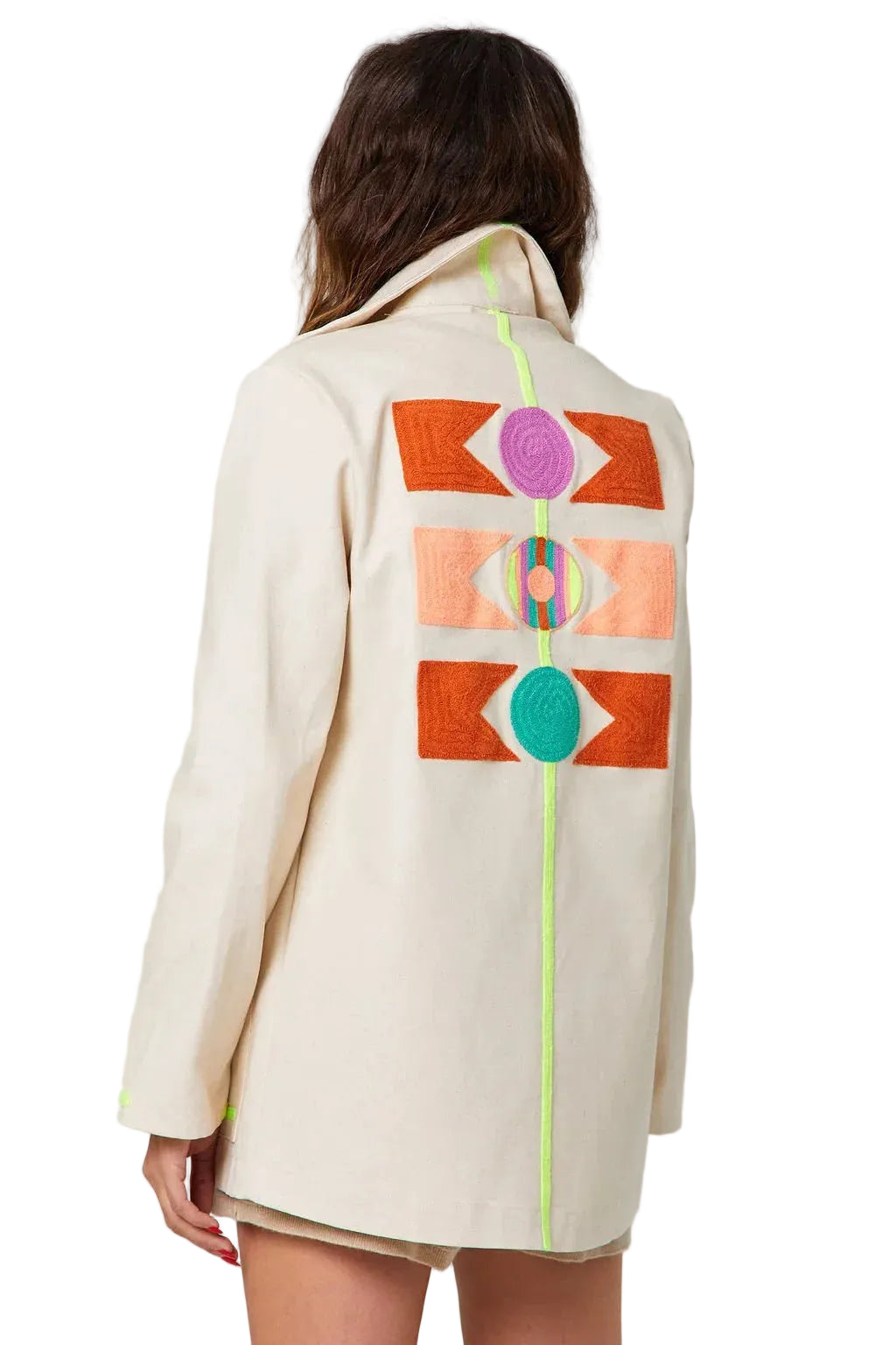 Beige coat with colorful geometric patterns on the back, worn by a person against a plain background
