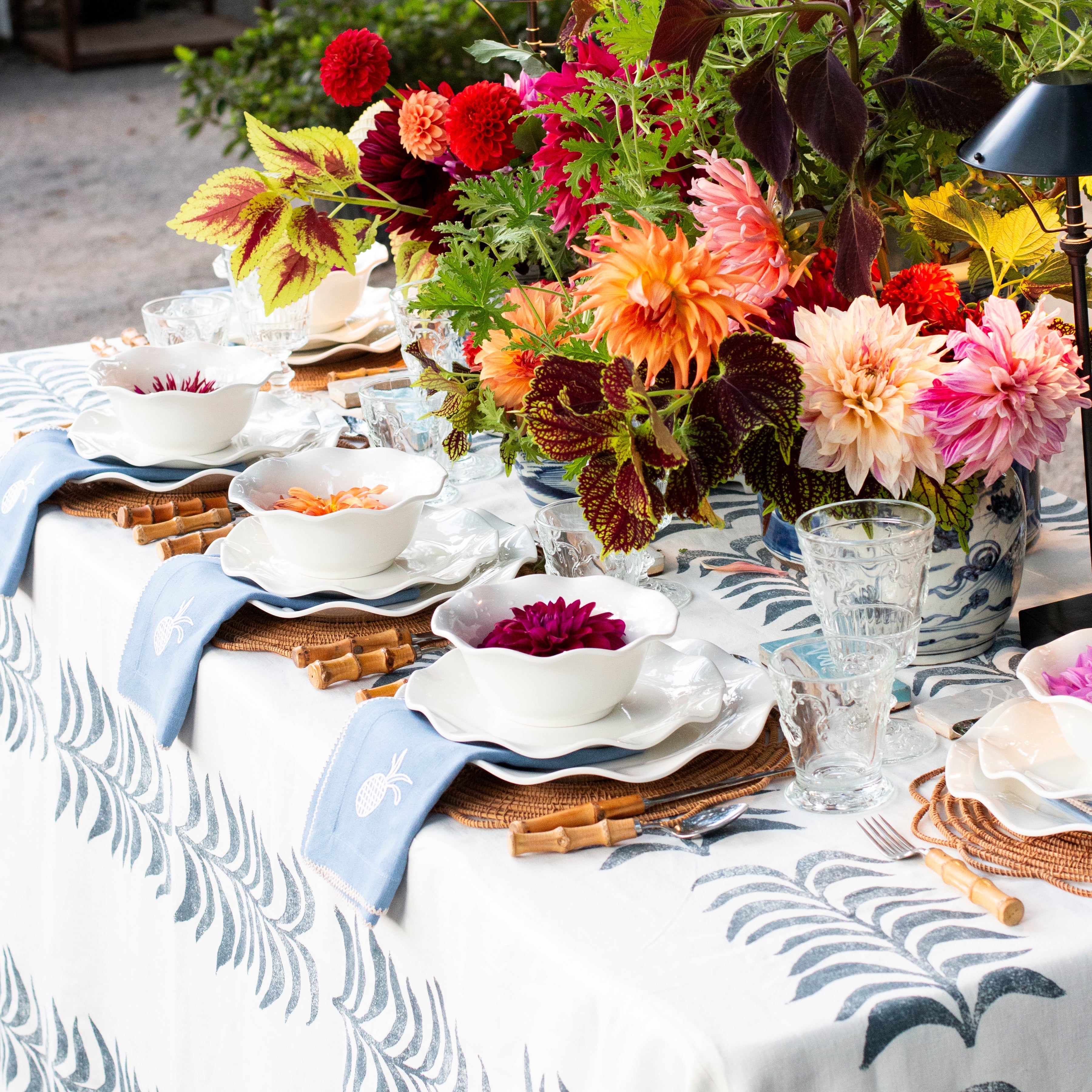 Decorative table setting with floral arrangements and patterned tablecloth