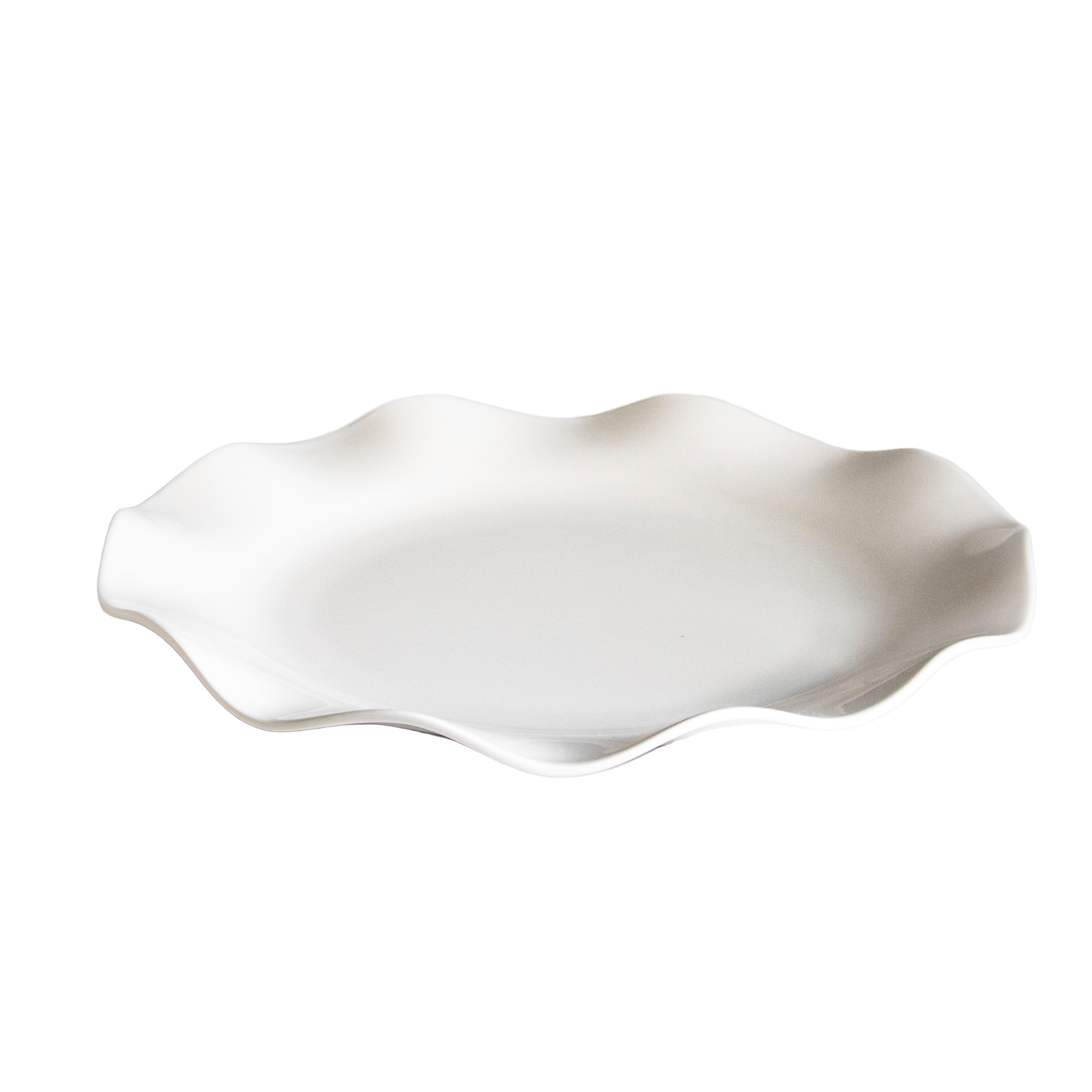 White ceramic dish with wavy edge on a white background