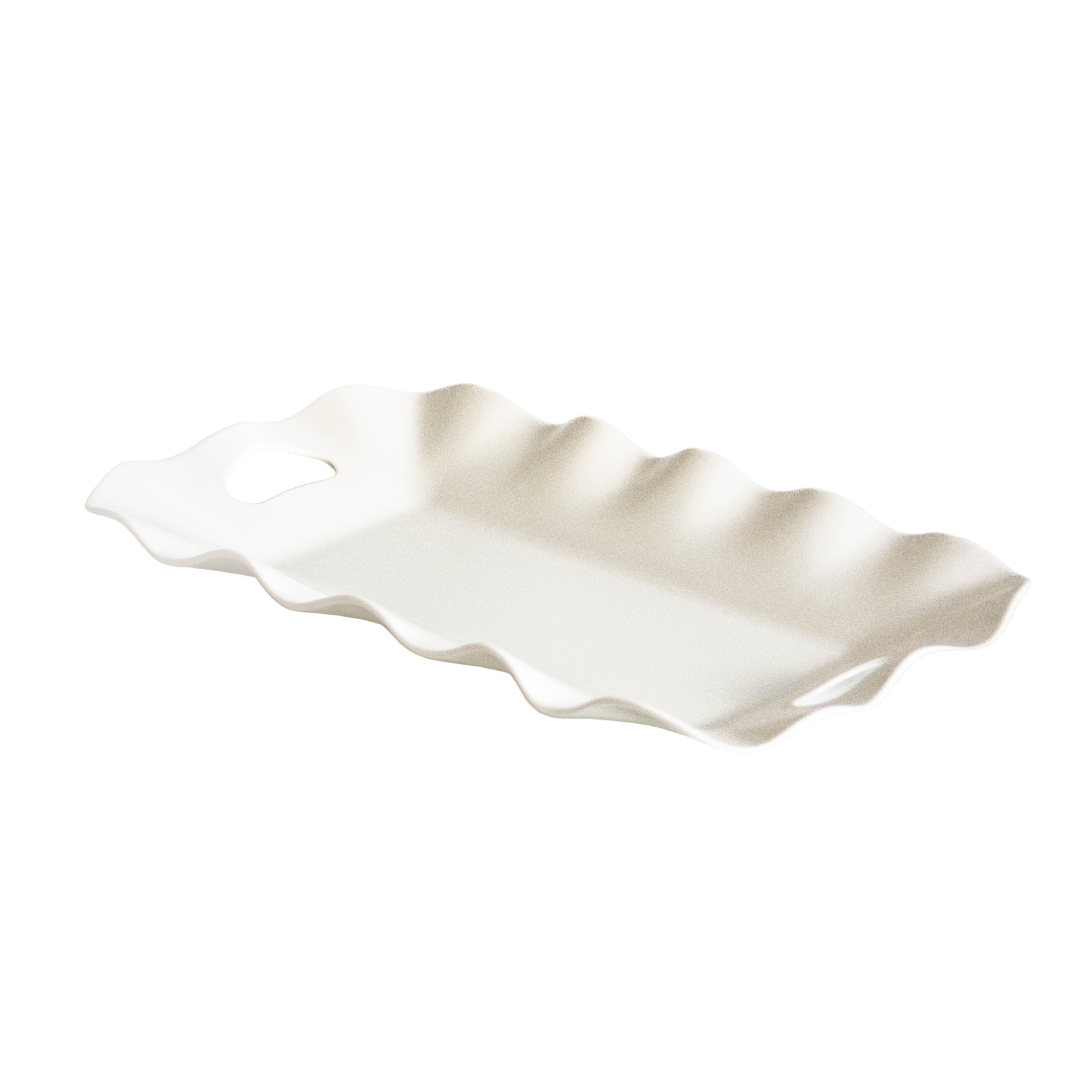 White ceramic dish with wavy edge on a white background