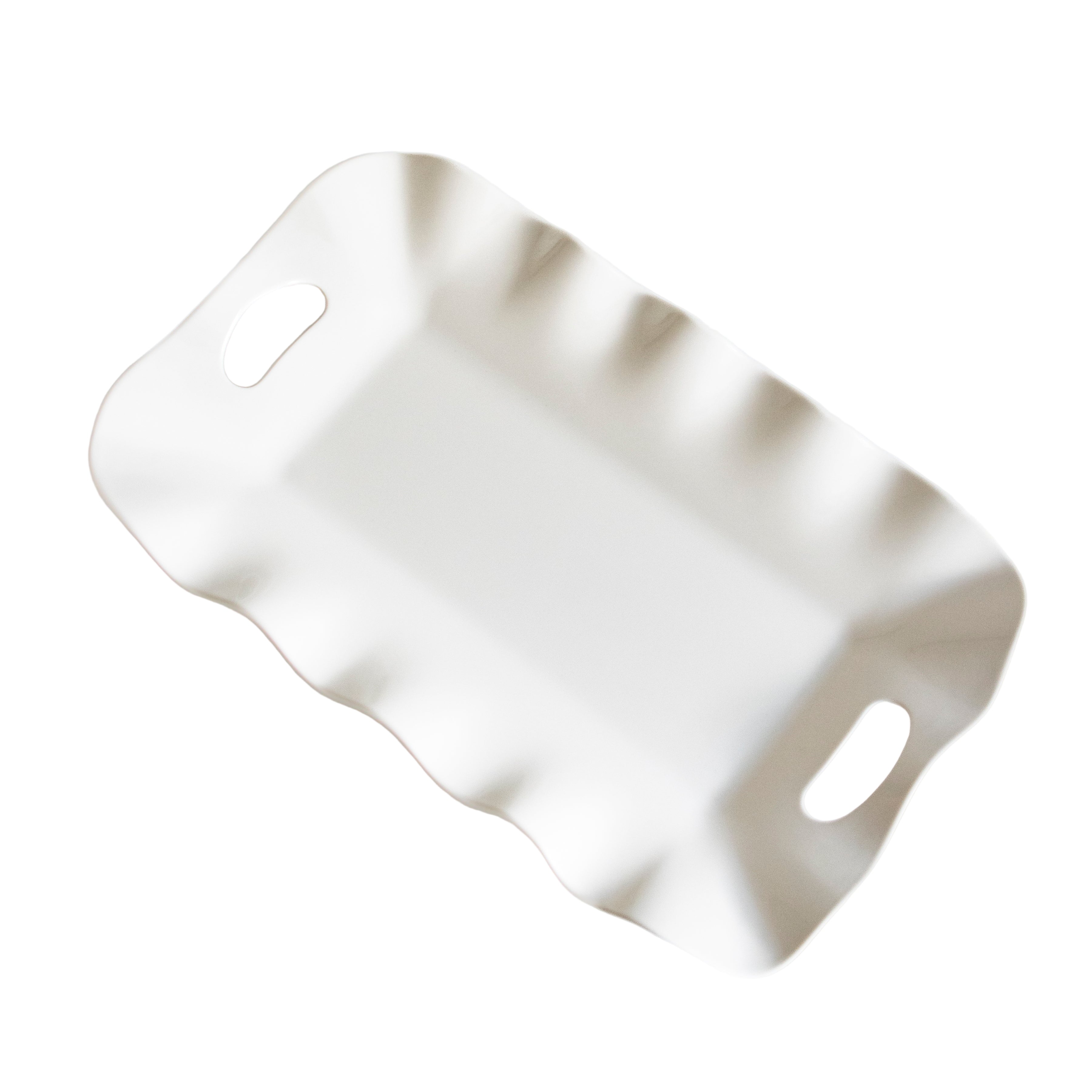 White ceramic tray with wavy edge on a light gray background