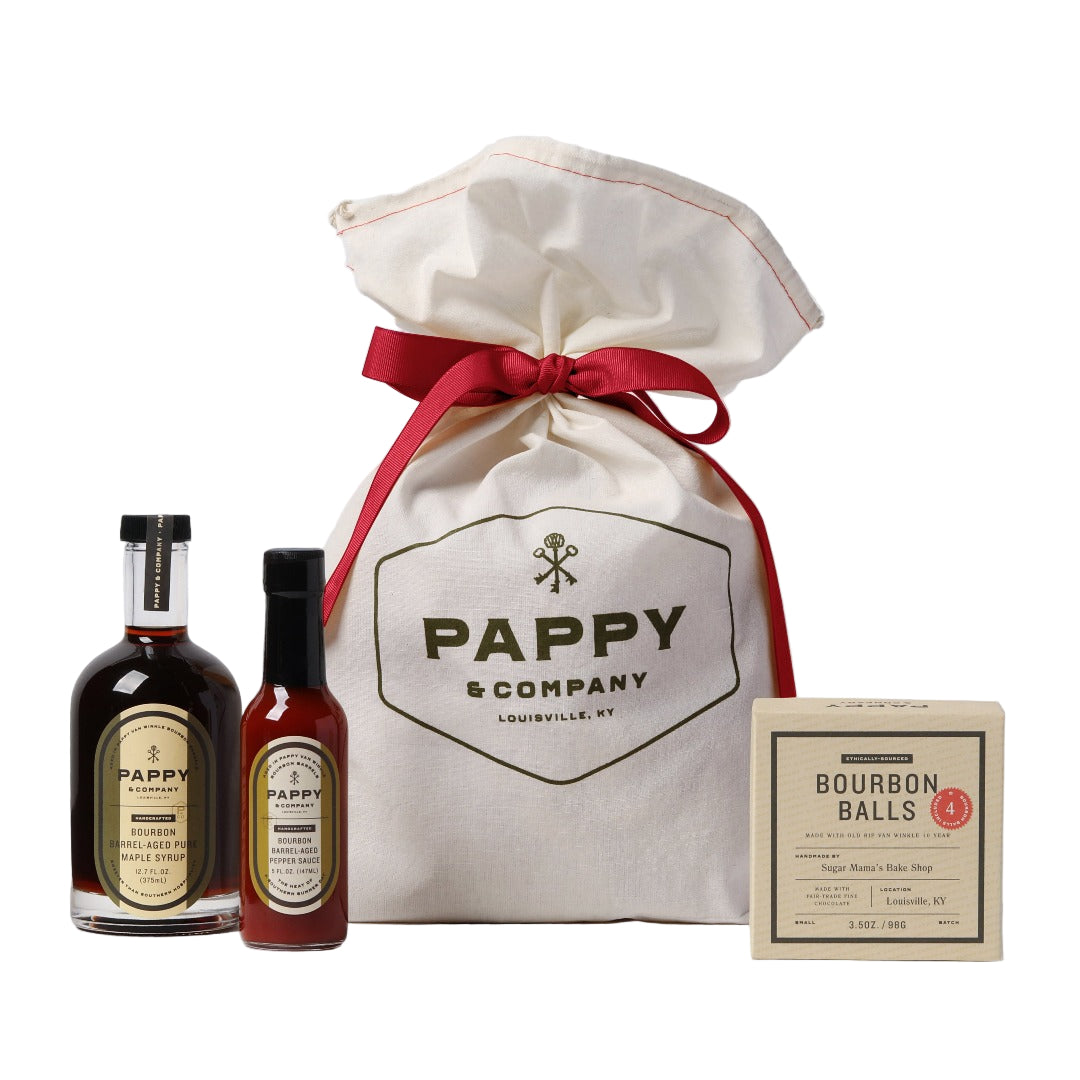 Pappy & Company bottles with a branded bag and bourbon balls packaging on a light gray background