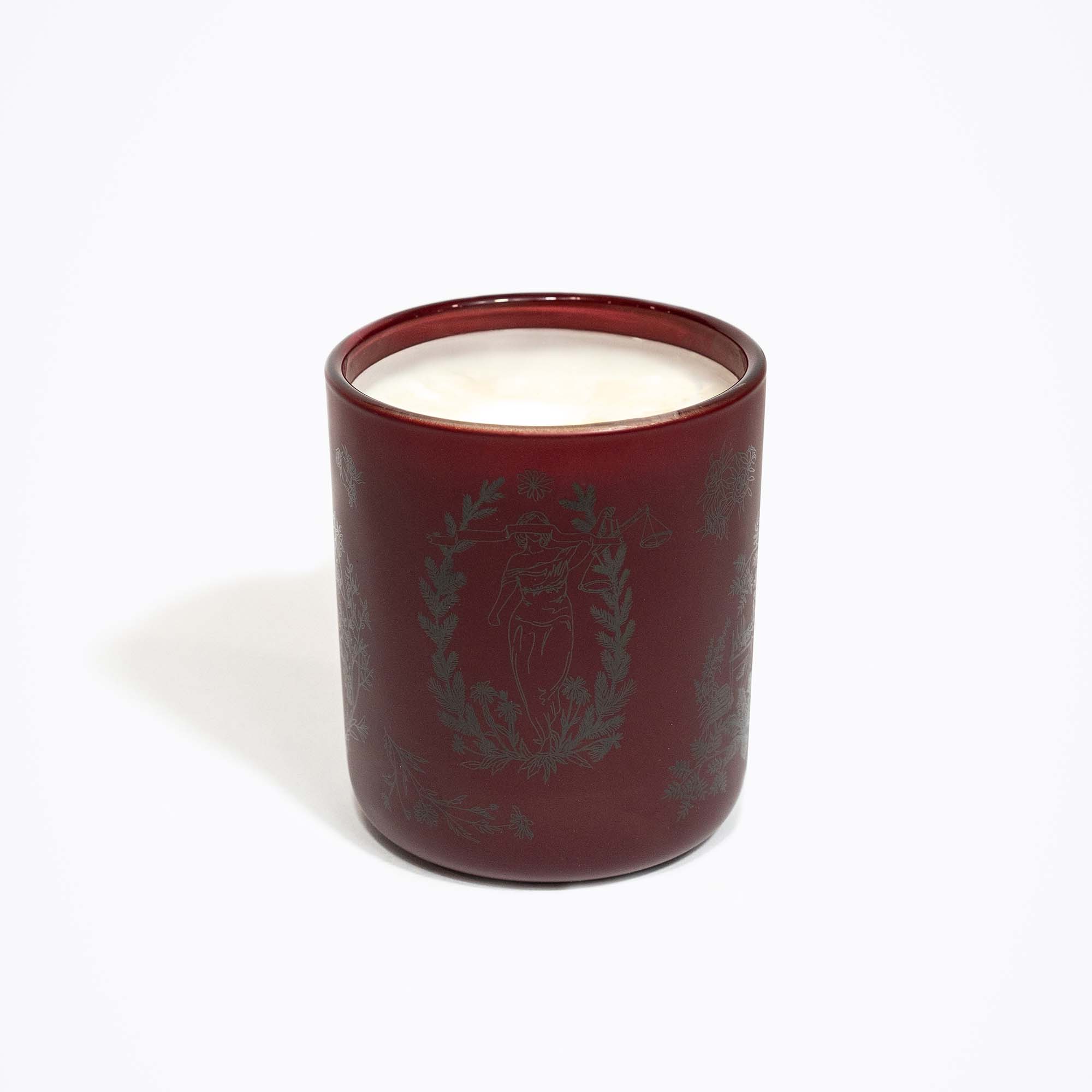 Red candle with a decorative design on a white background
