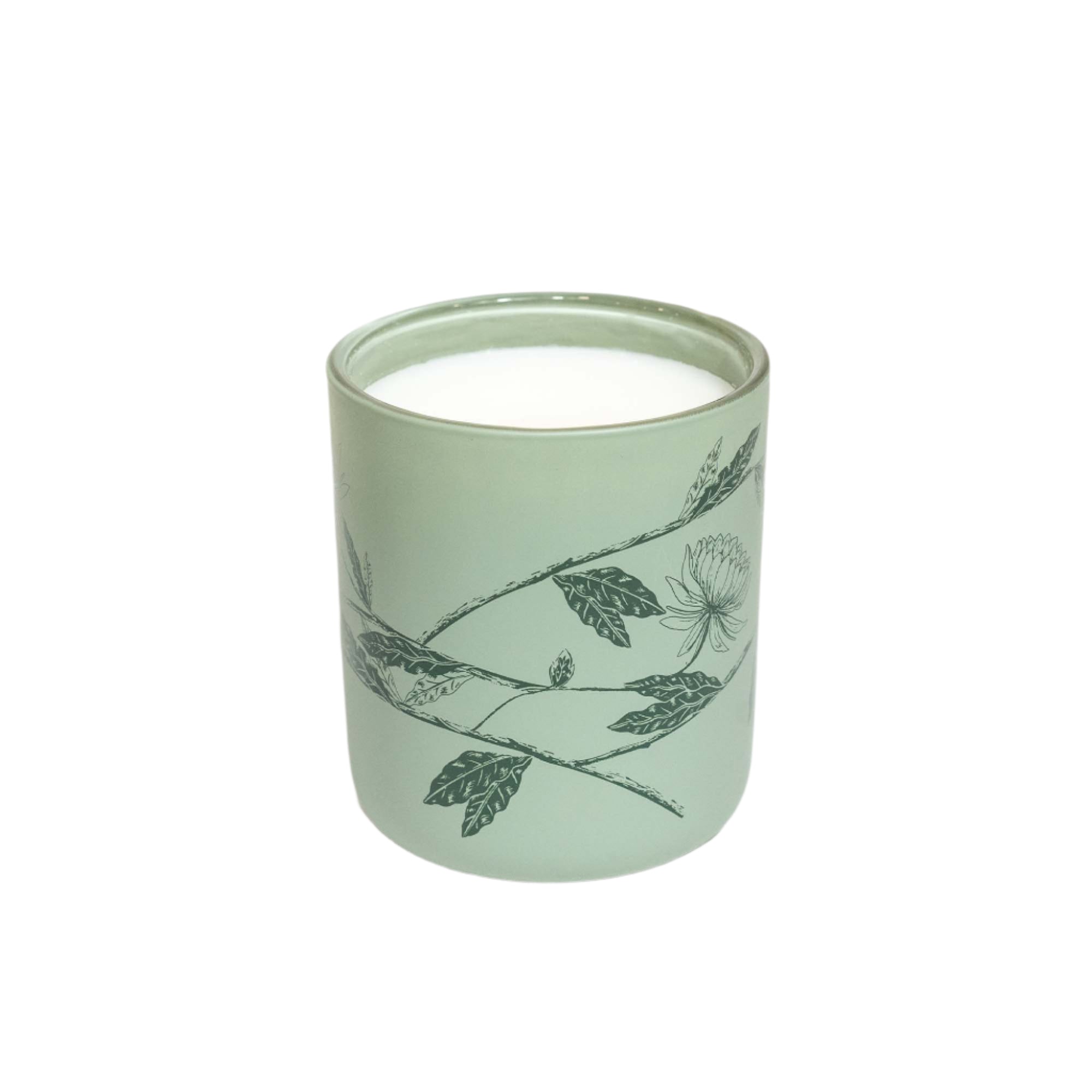 Green candle with leaf design on a white background