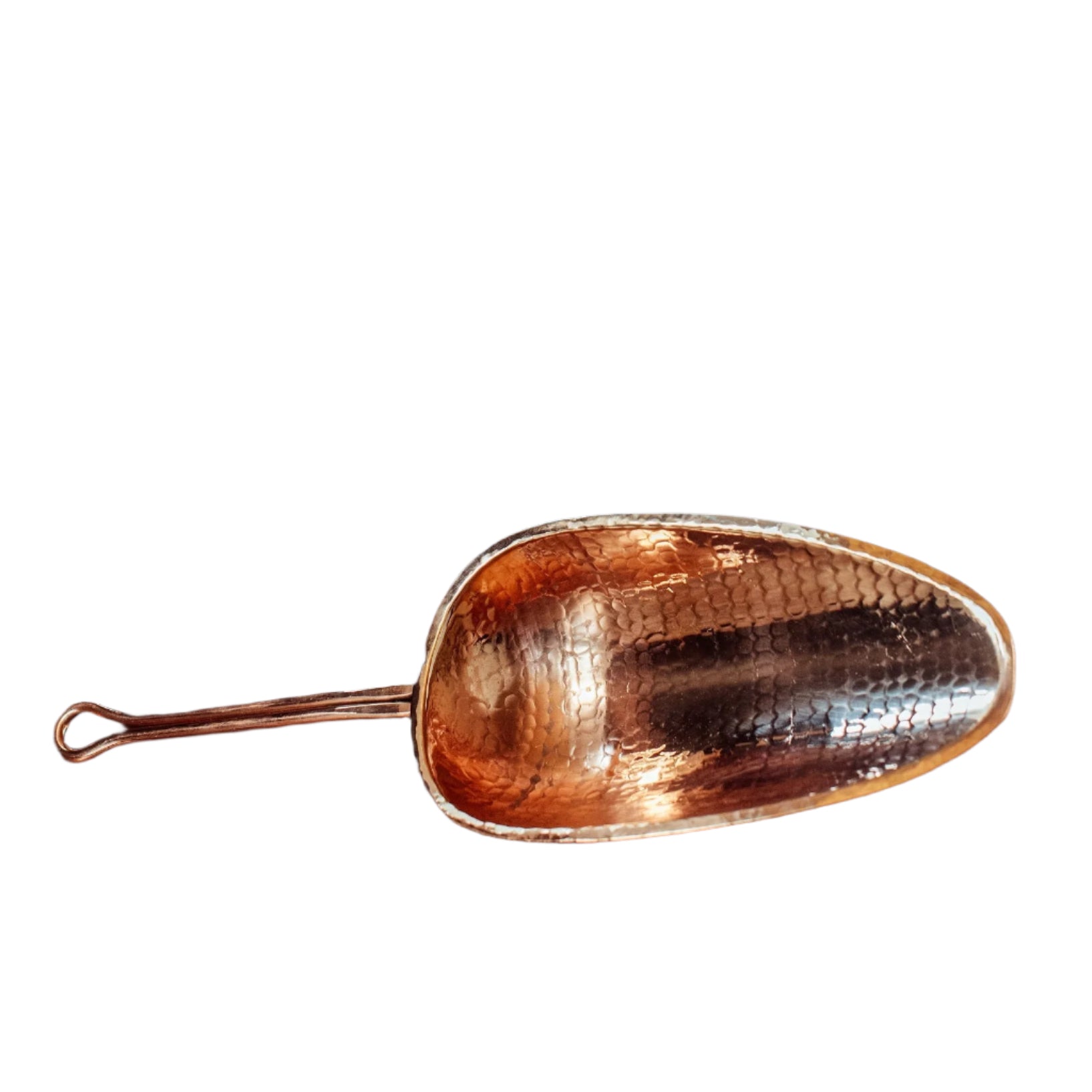 Copper scoop on a wooden surface with a dark background