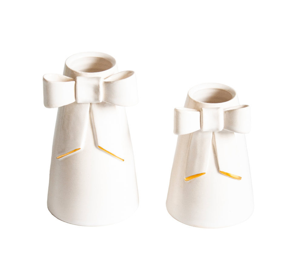 Two white ceramic vases with gold accents on a light gray background