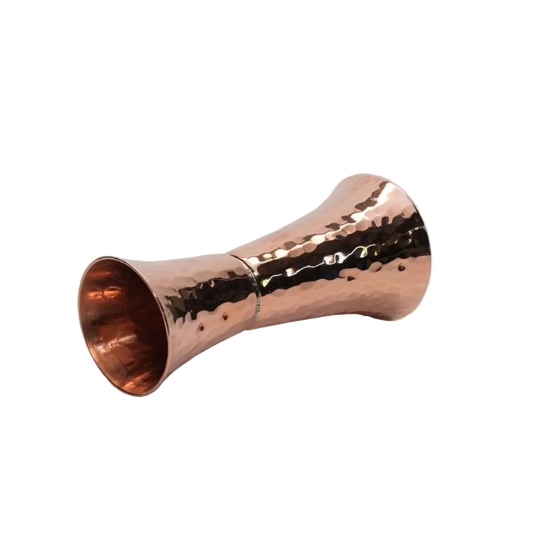 Copper hammered cocktail shaker on a light gray background