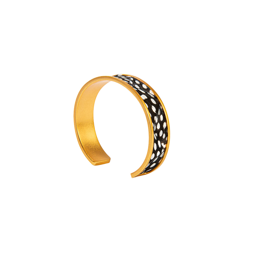 Gold bracelet with black and white pattern on a white background