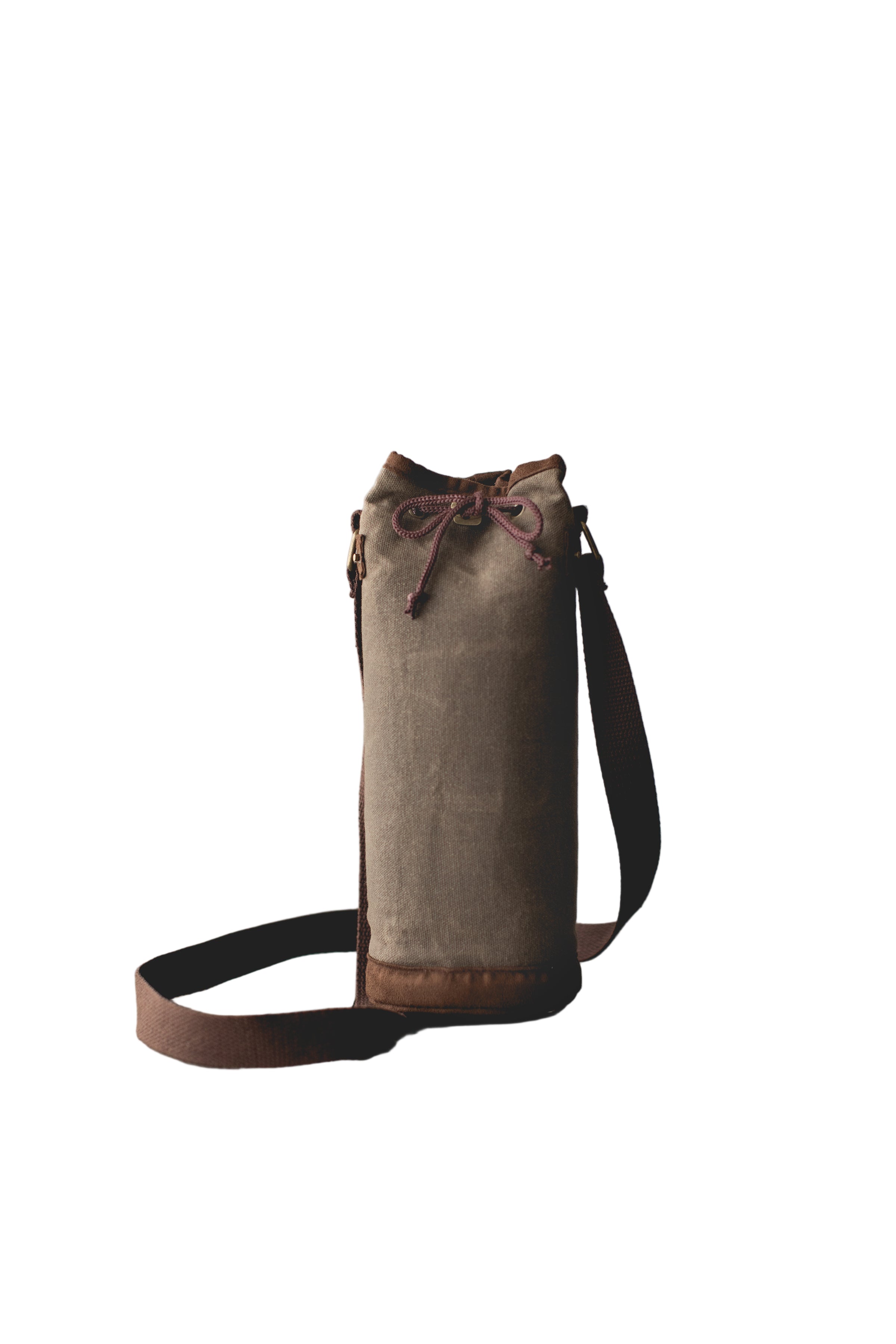 Brown leather bag with a strap on a wooden surface and gray background
