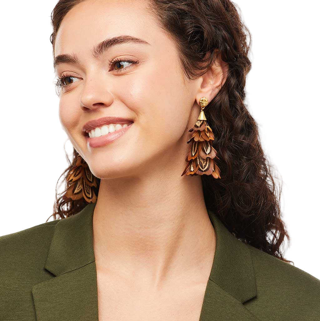 Woman wearing a pair of wooden earrings with a green blazer on a white background